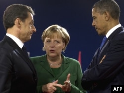 French President Nicolas Sarkozy (left), his U.S. counterpart, Barack Obama, and German Chancellor Angela Merkel talk in Cannes on November 3.