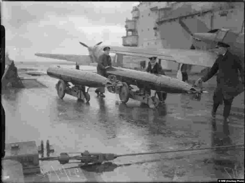 Crew members of the &quot;HMS Victorious&quot; move torpedoes while taking part in an operation to cover a Russian convoy.