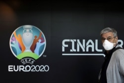Турист проходит мимо логотипа чемпионата Европы по футболу 2020 года. Бухарест, Румыния. 16 марта 2020 года.