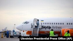 Група медиків поблизу літака авіакомпанії SkyUp, який прилетів з китайського міста Ухань, лютий 2020 року, «Бориспіль», Україна