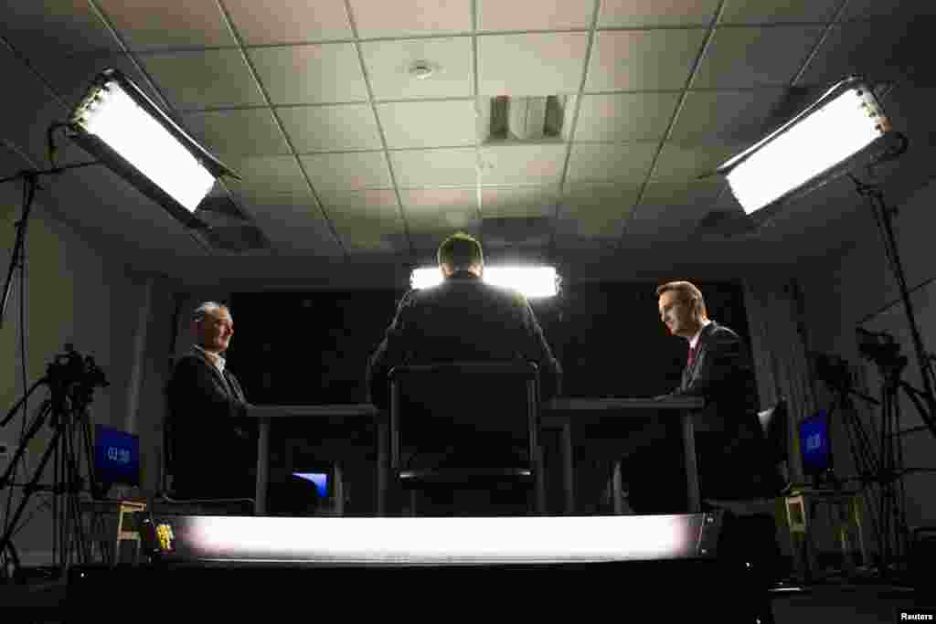Russian opposition leader Aleksei Navalny (right) and Igor Strelkov (left), a former pro-Russia separatist commander who took part in the military conflict in eastern Ukraine, take part in a broadcasting debate in Moscow moderated by journalist Mikhail Zygar (center) on July 20.