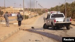 Iraqi police inspect the site of militant attack in the town of Haditha on March 5.