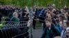 Demonstrators (right) stand outside a fence blocked by police as they protest plans to construct a church in a park in Yekaterinburg on May 14.