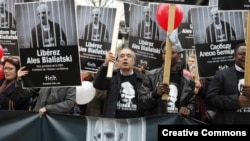 Supporters outside the Belarusian Embassy in Paris in 2011 hold signs of Ales Byalyatski.