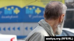 Зейнетақы қорының жарнамасына қарап тұрған қарт. Алматы, 29 наурыз 2012 жыл.