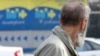 Жинақтаушы зейнетақы қорының көшедегі баннеріне қарап тұрған адам. Алматы, 29 наурыз 2012 жыл.