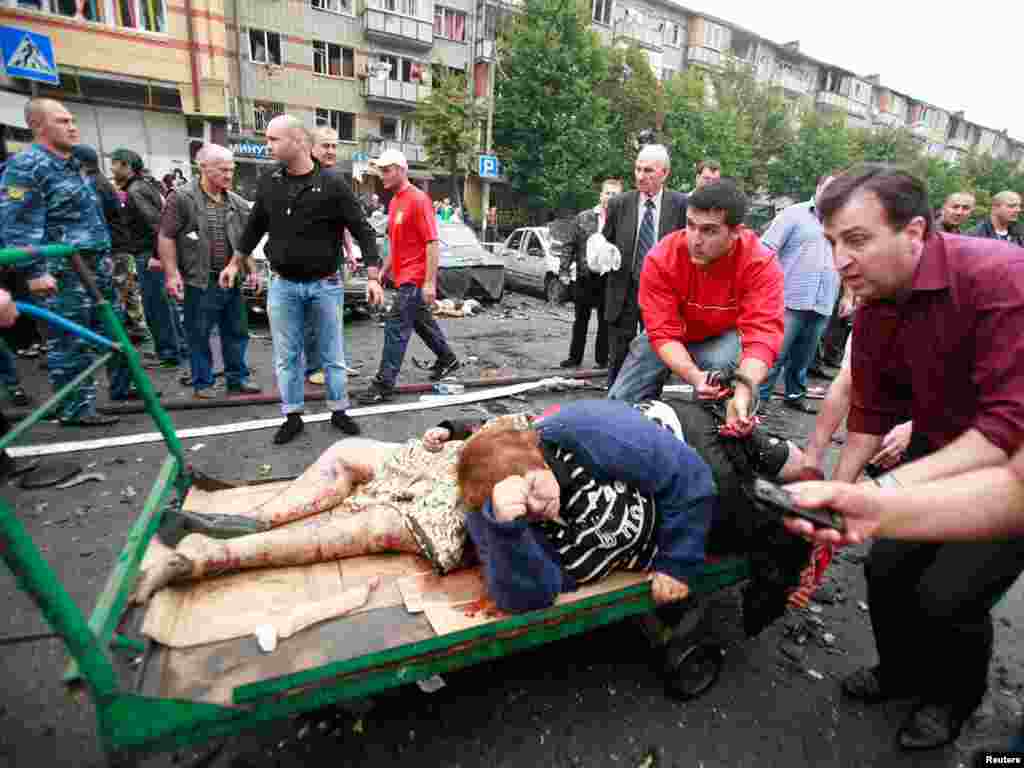 Люди помогают пострадавшим при взрыве на центральном рынке Владикавказа, 9 сентября 2010
