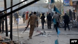 Pakistani security officials inspect the site of a bomb attack in Rawalpindi on January 20.