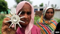 An Indian villager holds part of a mortar shell after alleged live fire from the Pakistan side of the Kashmir border on 16 July. 