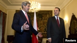 U.S. Secretary of State John Kerry (left) heads into a meeting with Polish Foreign Minister Radoslaw Sikorski in Warsaw on November 5.