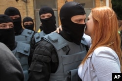 A woman says goodbye to a volunteer from the Social National Assembly before he and others were sent to eastern Ukraine to join the ranks of the Azov Battalion, in Kyiv in June 2014.
