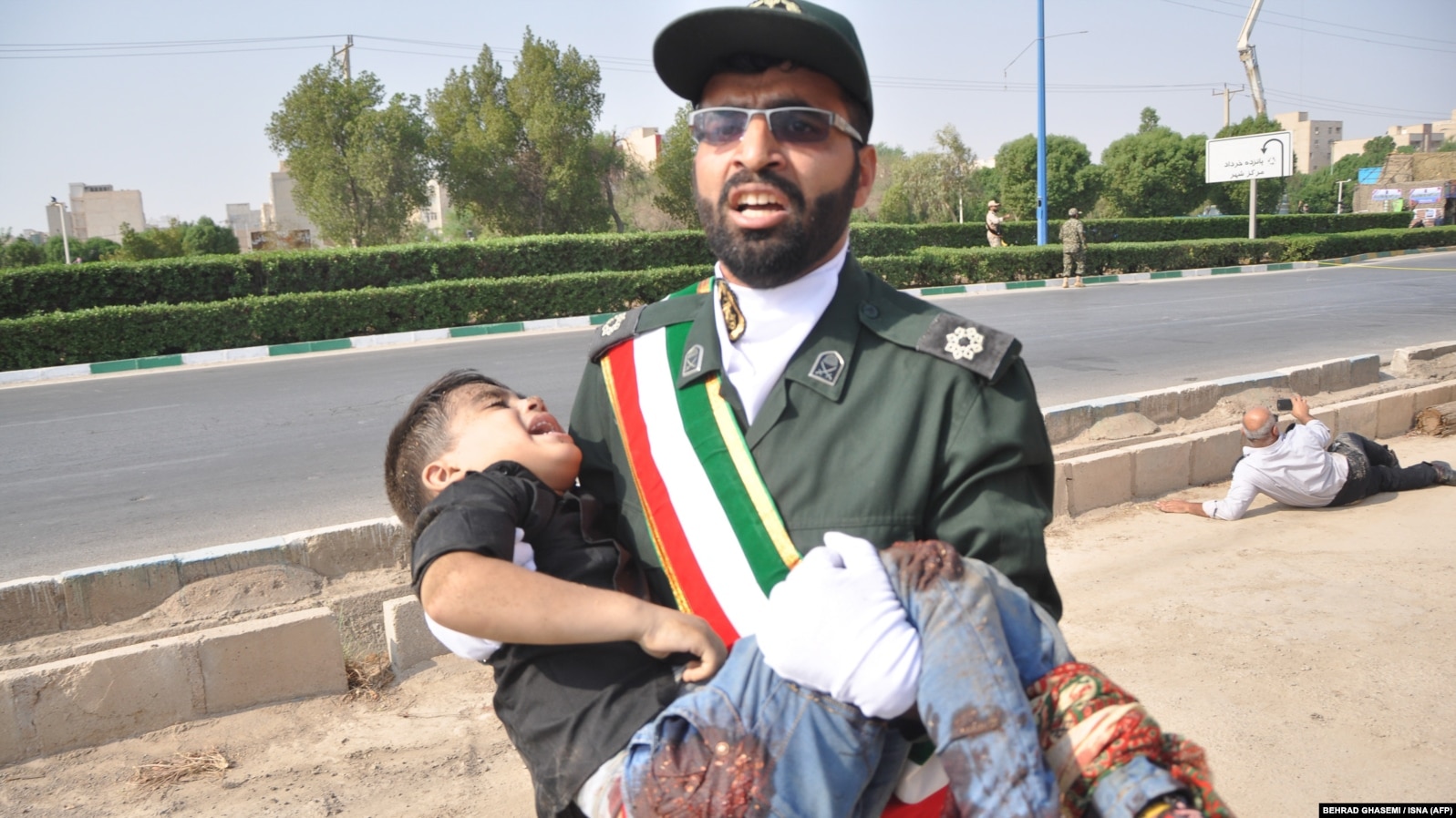 September 22, 2018 in the southwestern Iranian city of Ahvaz shows a member of Iran's Revolutionary Guards Corps (IRGC) carrying an injured child at the scene of an attack on a military parade. Ahvaz Iran