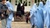 Əfqan polisi Heratda məişət zorakılığı mövzusunda seminardan çıxan burkalı qadınları qoruyur. 2009-cu il.