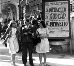 Червень 1944 року. Мешканці Одеси, яку було звільнено від нацистів у квітні, перед початком вистави біля будівлі Одеського театру опери і балету. Афіші з назвами вистав – українською мовою