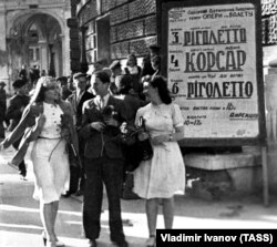 Червень 1944 року. Жителі Одеси, яку було звільнено від нацистів у квітні, перед початком вистави біля будівлі Одеського театру опери і балету. Афіші з назвами вистав – українською мовою