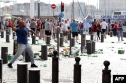 A man throws a beer bottle during street brawls ahead of the Euro 2016 football match England-Russia game in Marseille on June 11.