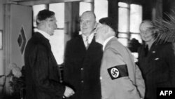 Адольф Гитлер беседует с британским премьером Невиллом Чемберленом (слева) в день подписания Мюнхенского соглашения