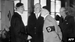 Вождь нацистов Адольф Гитлер беседует с британским премьером Невиллом Чемберленом (слева) в день подписания Мюнхенского соглашения
