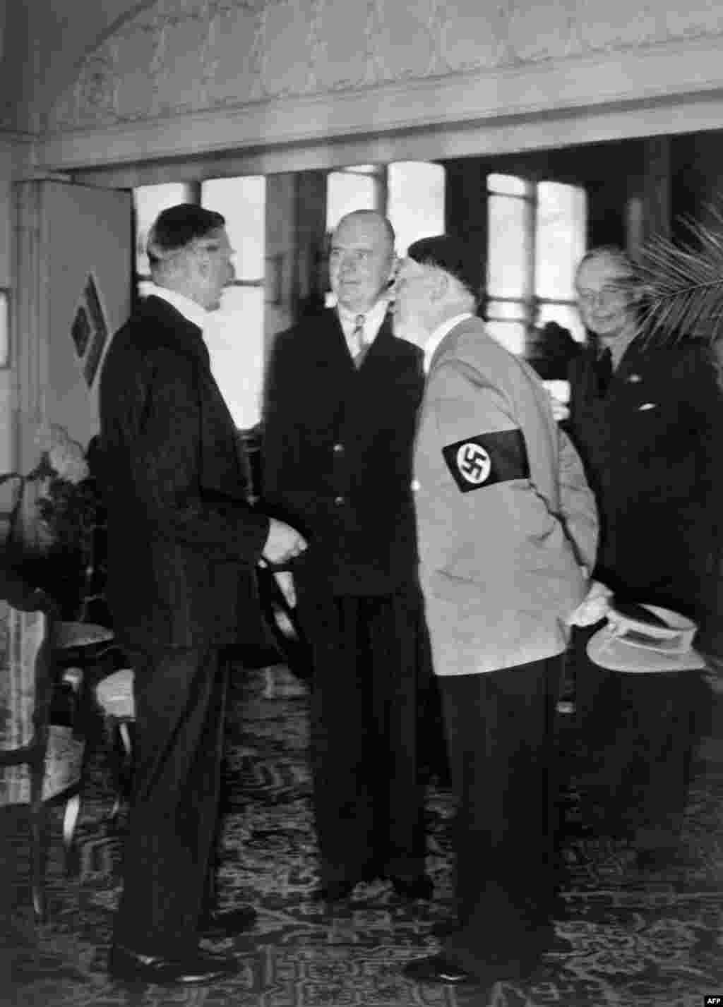 Neville Chamberlain (left) and Adolf Hitler talk with the help of an interpreter as German Nazi Foreign Minister Joachim Von Ribbentrop looks on in the background on September 23, 1938, in Bad Godesburg, Germany.