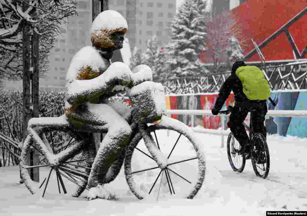 A cyclist passes by a street installation during snowfall in Stavropol, Russia, on January 31. (Reuters/Eduard Komiyenko)