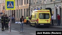 تاکسی مورد نظر در برابر آمبولانسی که برای کمک به زخمی‌ها آمده است در نزدیکی میدان سرخ مسکو