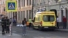 An ambulance is parked near a damaged taxi, which ran into crowds of people in Moscow on June 16.