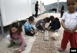 Дети играют в "официальном" лагере беженцев в окрестностях Афин