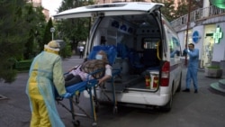 Armenia - An ambulance rescuer wearing a protective face mask and personal protective equipment moves a patient into the Grigor Lusavorich Medical Center in Yerevan on May 27, 2020.