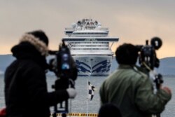 Японские журналисты в порту Иокогамы, впереди - лайнер Diamond Princess. 6 февраля 2020 года