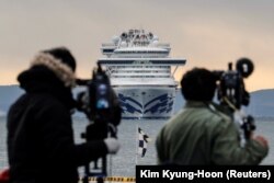 Японские журналисты в порту Иокогамы, впереди - лайнер Diamond Princess. 6 февраля 2020 года