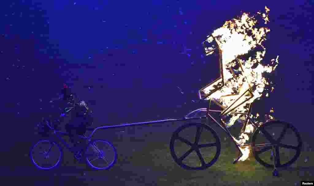 A performer cycles in the Olympic Stadium during the closing ceremonies of the London 2012 Paralympic Games. (Reuters/Toby Melville)