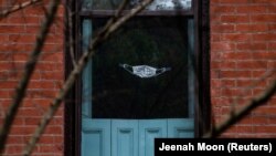 Захисна маска на дверях помешкання в нью-йоркському районі Бруклін під час пандемії коронавірусу