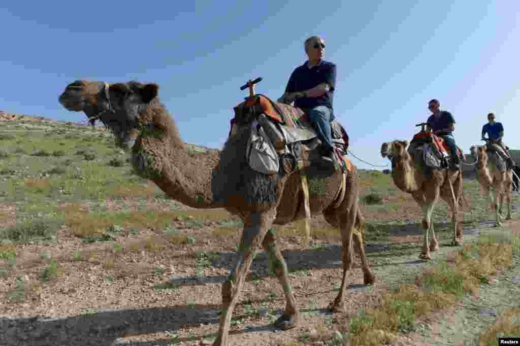 Israeli Prime Minister Benjamin Netanyahu (left) and his sons ride camels as they vacation in Israel, on April 8. (Reuters)