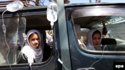 FILE: Afghan schoolgirls receive medical treatment outside a local hospital after being admitted for symptoms of poisoning in Herat in 2015.