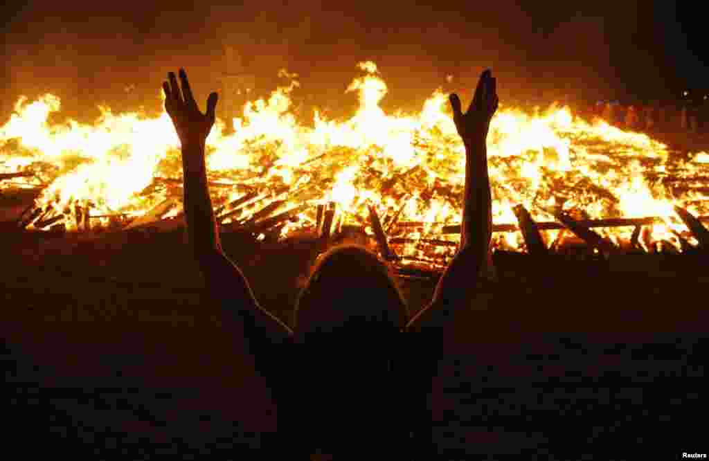 A man pays homage to the pyramidic &quot;Temple of Whollyness&quot; as it burns toward the end of the 2013 Burning Man. 