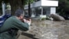 A man shoots a tranquilizer dart to put a hippopotamus to sleep on a flooded street in Tbilisi following a deadly flash flood. Animals from the city's zoo, including tigers, lions, bears, and wolves escaped from cages damaged by the rainfall. Some were captured or killed while the search for others goes on. (Reuters/Beso Gulashvili)(Re