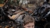 Восточная Украина. Новоалексеевка. Подросток на фоне подорванного грузовика и своего разрушенного дома