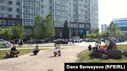 Люди фотографируются на фоне городского пейзажа в Астане.