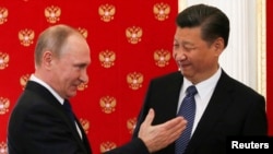 Russian President Vladimir Putin (left) greets Chinese President Xi Jinping at a meeting in the Kremlin in Moscow on July 3.