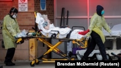 Парамедики несут пациента в центр оказания экстренной помощи в Нью Йорке. 14 апреля 2020 года. 