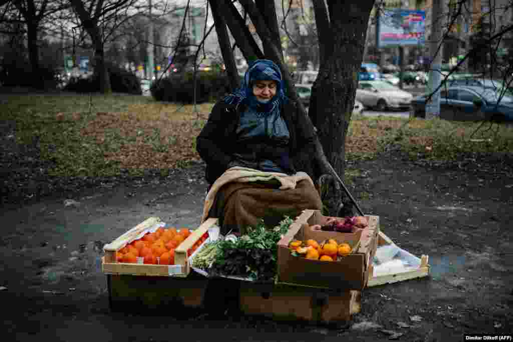 Москванын көчөлөрүнүн биринде анар, курма жана мандарин сатып отурган аял. Орусия.&nbsp;