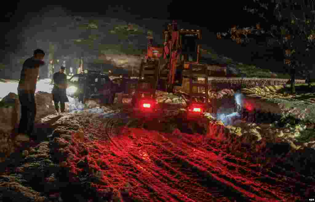 Afghan authorities clear a road as part of rescue efforts. Heavy snow blocking traffic on the roads has made it difficult for rescue workers to reach the affected villages.