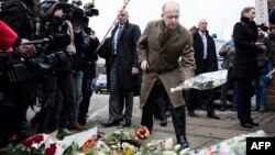 French Interior Minister Bernard Cazeneuve (center) lays flowers outside the Krystalgade synagogue in Copenhagen on February 15 after two attacks in the Danish capital, at a cultural center during a debate on Islam and free speech and a second outside a synagogue left two people dead.