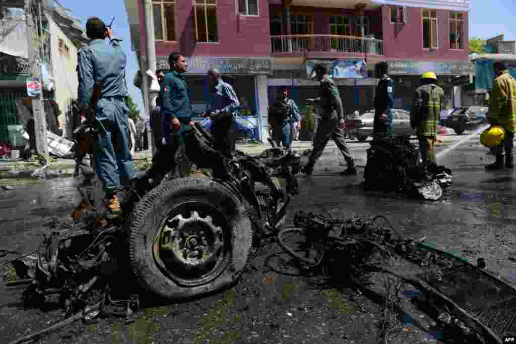 Afghan policemen inspect the aftermath of a suicide car bomb in Kabul on May 16. (AFP/Massoud Hossaini)