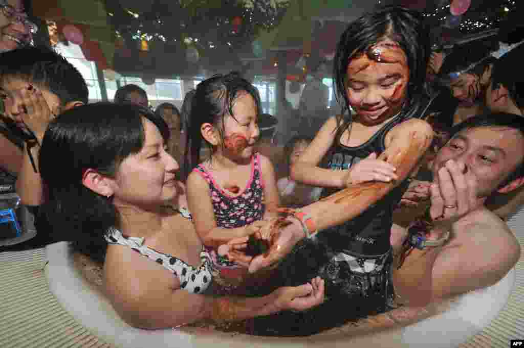 Visitors to a &quot;chocolate spa&quot; that&#39;s part of a St. Valentine&#39;s Day promotion enjoy the fun at a resort in Hakone, Japan. (AFP/Kazuhiro Nogi)