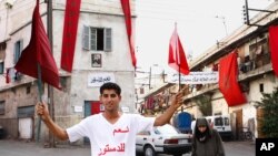 A man wearing a T-shirt, which has "I say yes to the constitution" printed on it, holds a Moroccan flag on the street of Casablanca during protests earlier this year.