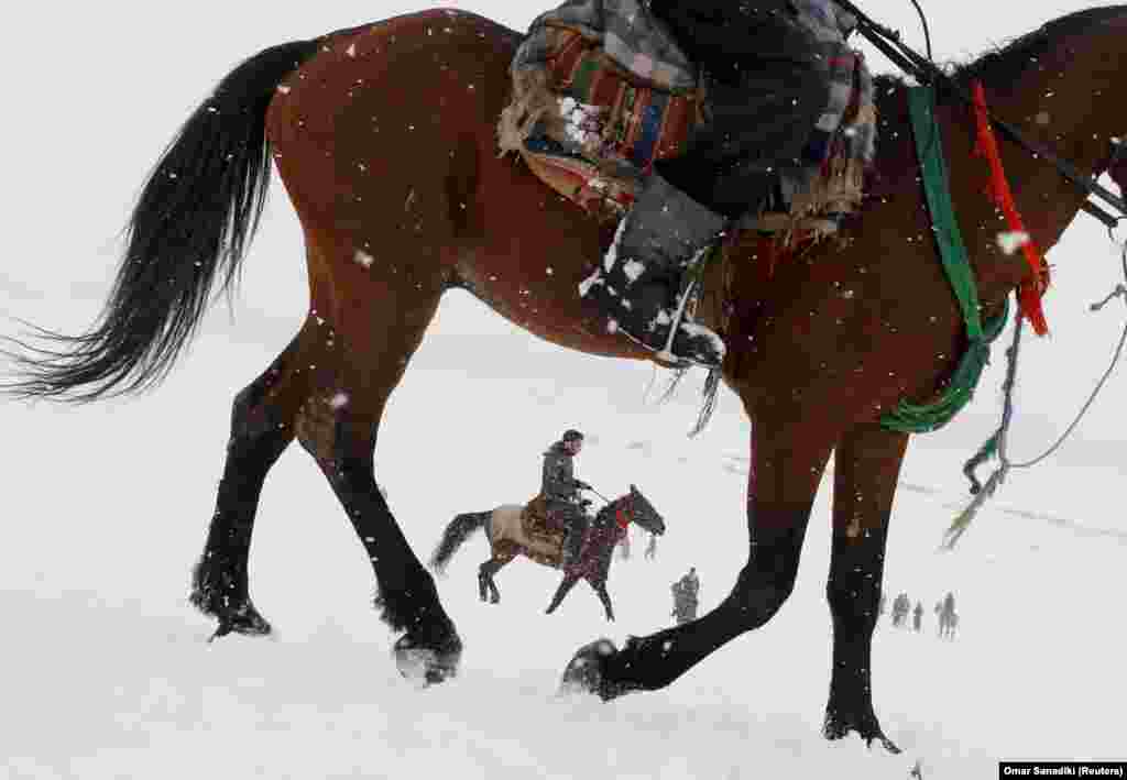 Afghan men ride horses on snow-covered ground on the outskirts of Kabul. (Reuters/Omar Sobhani)