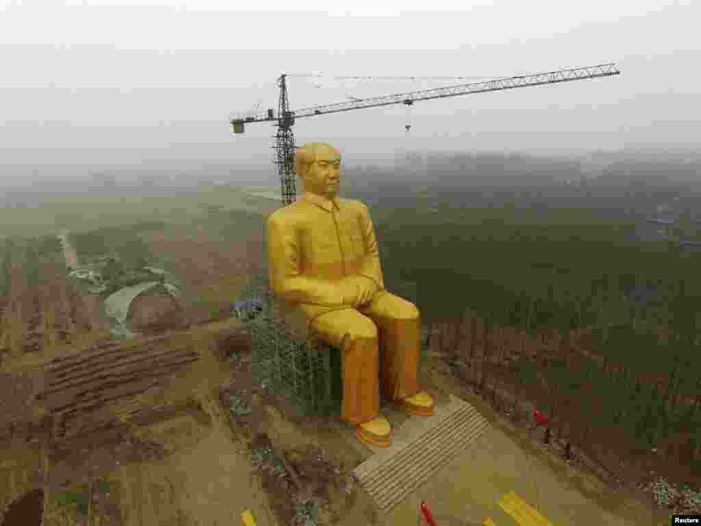 A crane is seen next to a giant statue of late Chinese leader Mao Zedong under construction near crop fields in a village of Tongxu county, Henan Province, on January 4. State media reports now say that the statue has been demolished, apparently because it lacked government approval. (Reuters)