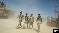 Polish soldiers walk past mine resistant armored vehicles at a forward operating base in Ghazni, Afghanistan. (file photo)