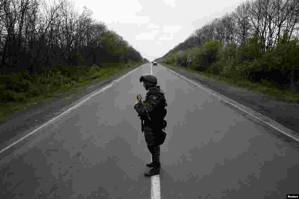 A Ukrainian soldier stands guard on a road at a checkpoint near the village of Malinivka, southeast of Slovyansk, on April 29. (Reuters/Baz Ratner)